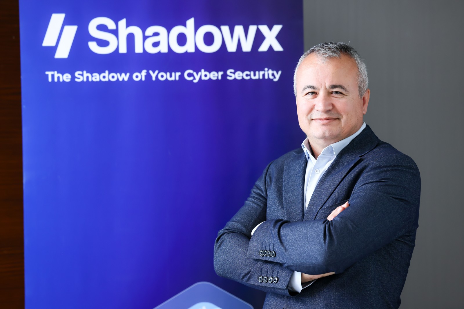 Shadowx markalı pano önünde takım elbiseli şirket temsilcisi.