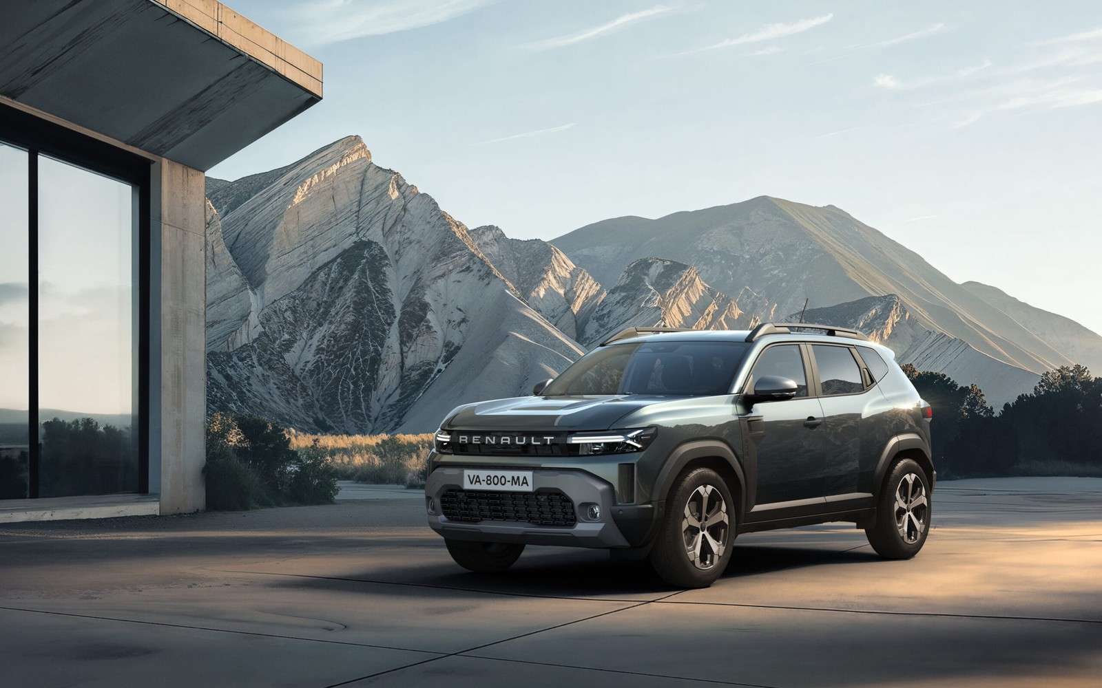 Dağ manzarası ve modern bina önünde duran koyu gri Renault SUV, tanıtım görseli